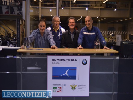 Natale Saguto, Maurizio Ghislanzoni, Mansueto Zanini, Federico Bartoli davanti al logo del motoclub nella concessionaria Lario Motorrad Lecco
