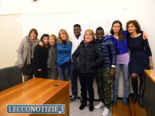 Il gruppo di volontari al campo profughi del Bione con due degli ospiti