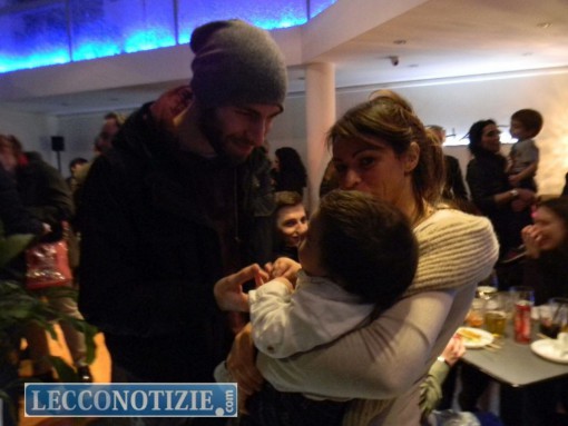 Il piccolo Andreas in braccio a mamma Manar accoglie gli ospiti dell'aperitivo solidale