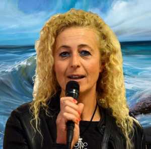 La pittrice Angela Marabese davanti a una sua opera